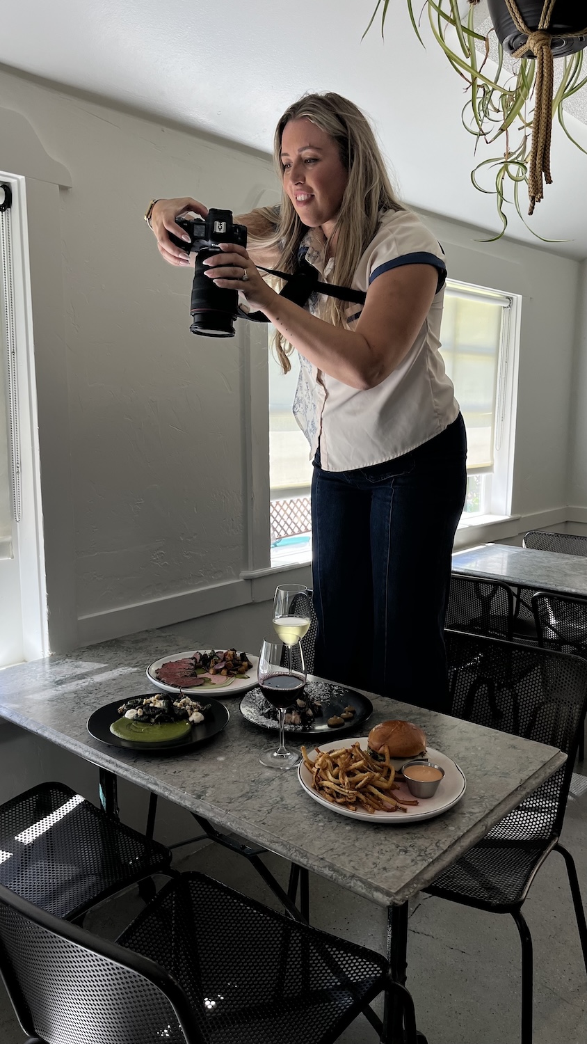 Cali Warner photographing branded restaurant content for social media storytelling and marketing campaigns.