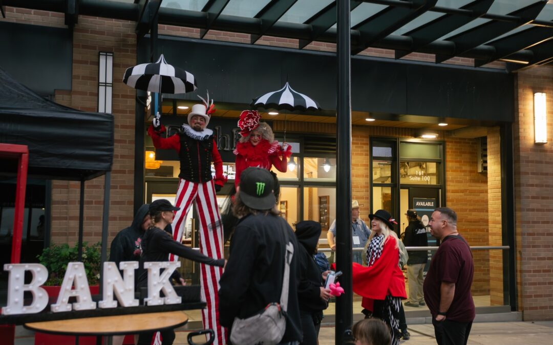 Performers on stilts welcoming attendees at Busker Fest SLC during an event marketing campaign managed by Elle Marketing and Events