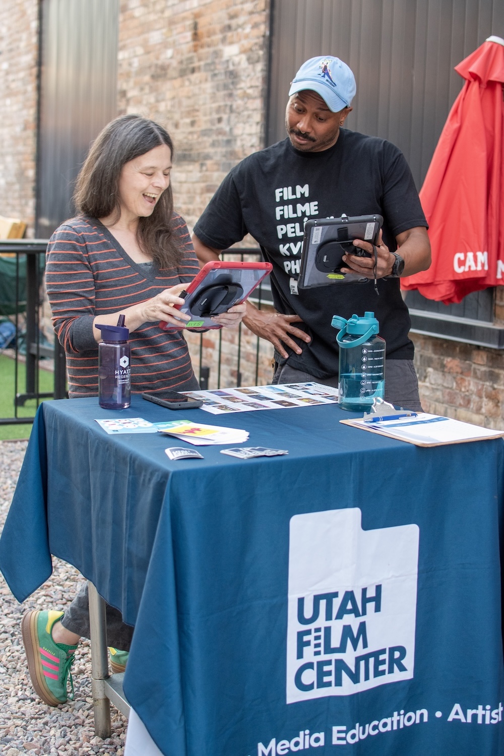 Utah Film Center staff welcoming guests to Movies in The Alley at Woodbine Food Hall before the outdoor screening.